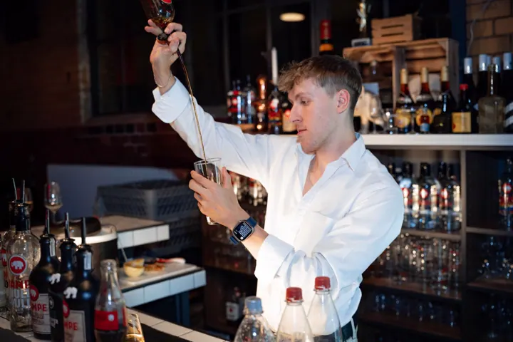 Teilnehmer stößt mit einem Glas an
