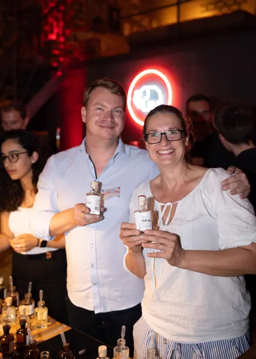 Gäste im Gespräch vor der Neon-Wand bei Mampe