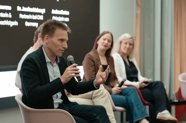 Panelgespräch mit Mikrofon beim Gründer- und Unternehmer:innenforum